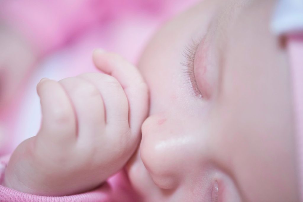 baby sleeping while thumb sucking