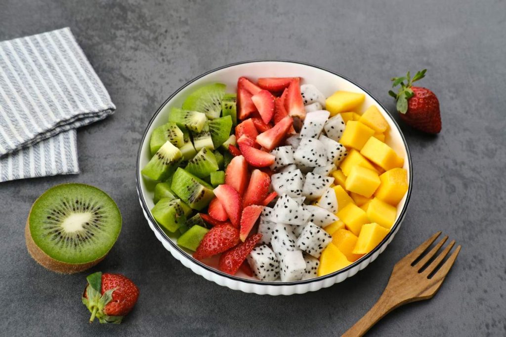 Healthy fresh fruit salad bowl, dragon fruit, kiwi, mango, and strawberry