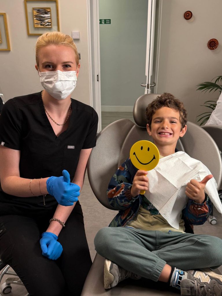 Child smiling during early orthodontic appointment with orthodontist in London