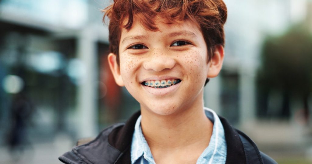 Smiling Boy with Braces in a City Environment