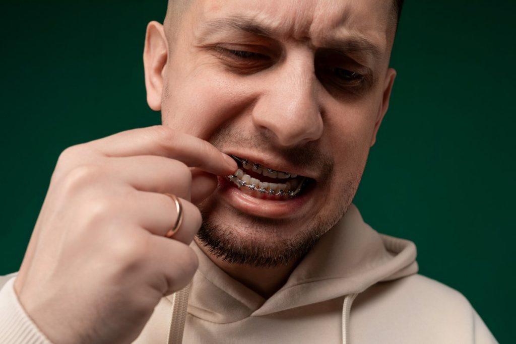 Man in White Hoodie Brushing Teeth
